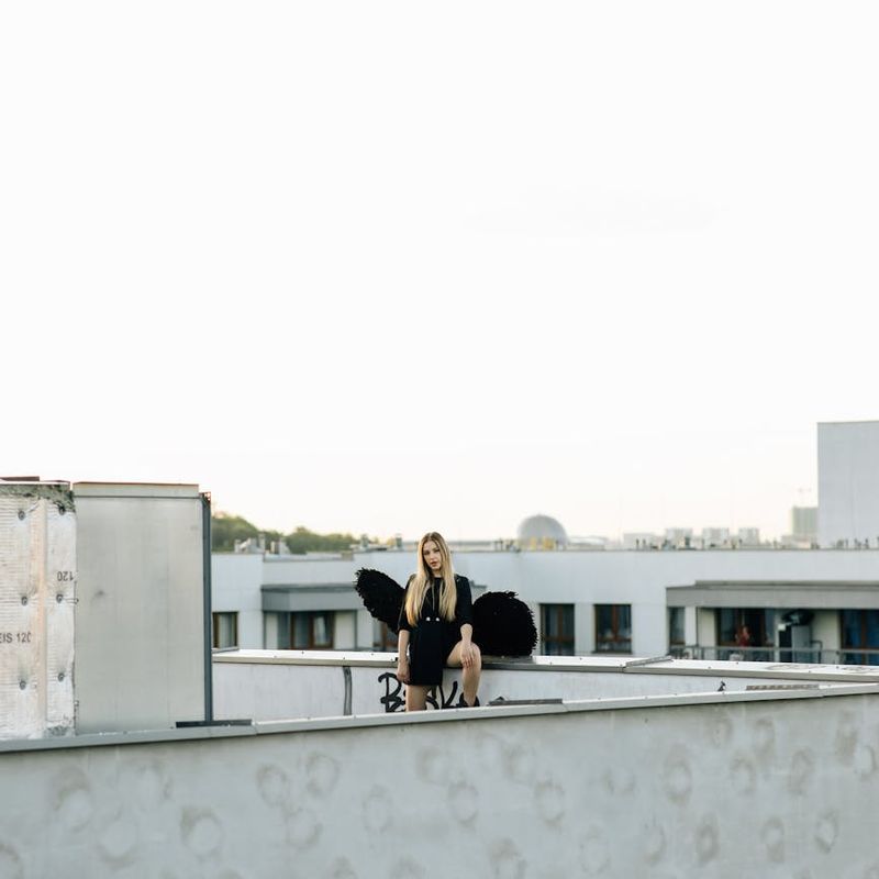 Woman practicing yoga on a city rooftop with the skyline in the background.